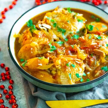 Chicken tagine in a bowl next to a string of red beads