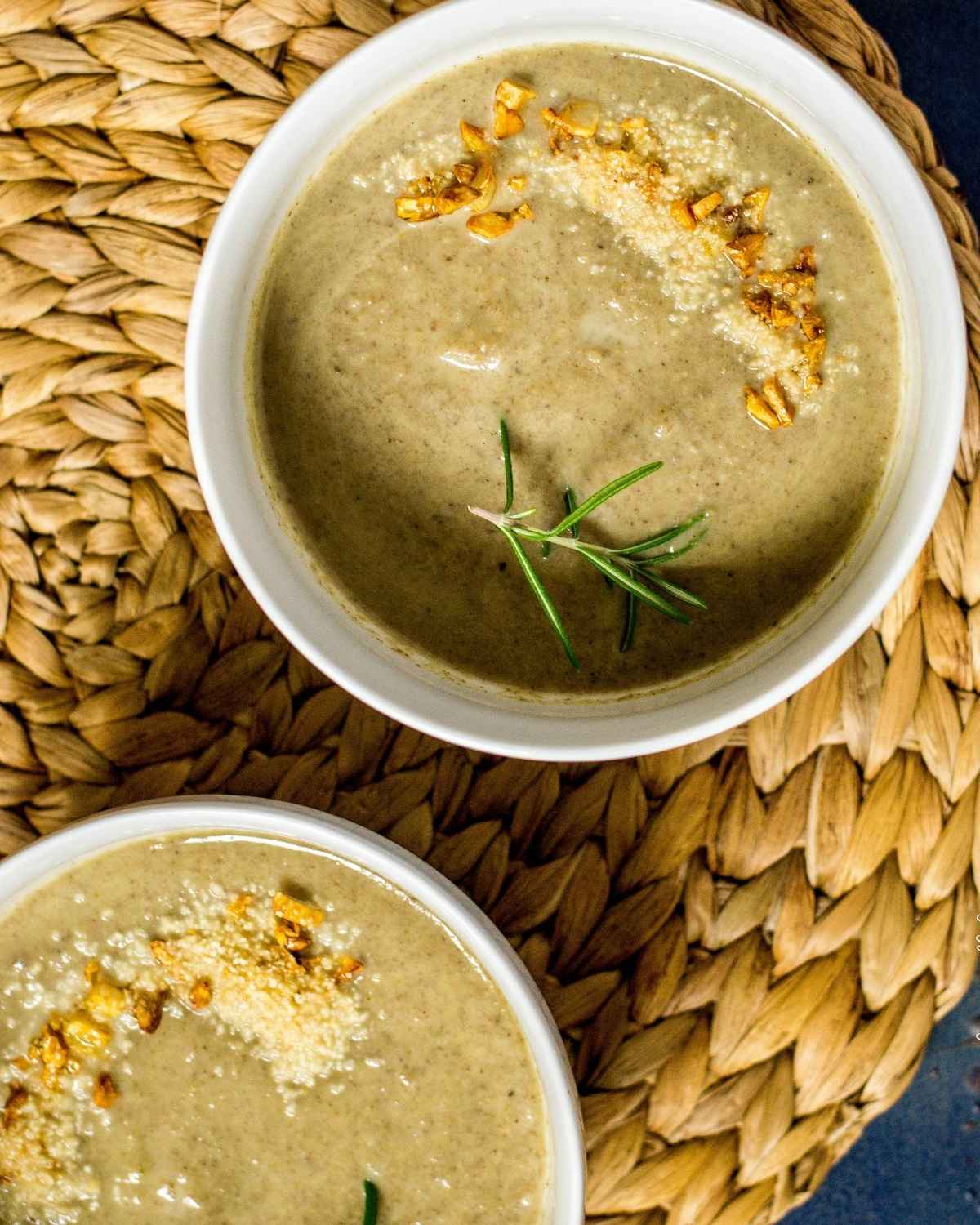 two bowls of soup on a brown rattan mat 