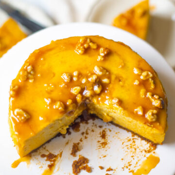 Pumpkin Cheesecake on a white cakestand with a section cut out