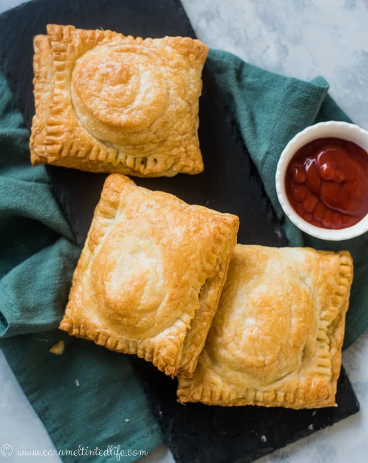 Egg puffs lying on a black serving plate, with ketchup