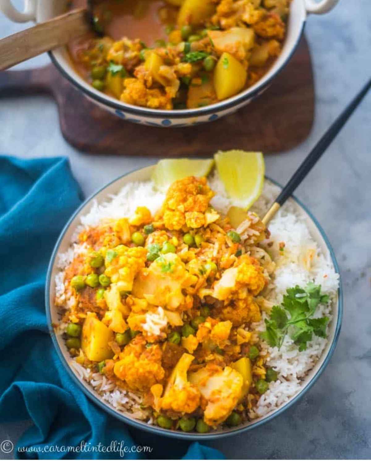 Cauliflower, peas and potato curry plated in a bowl with rice