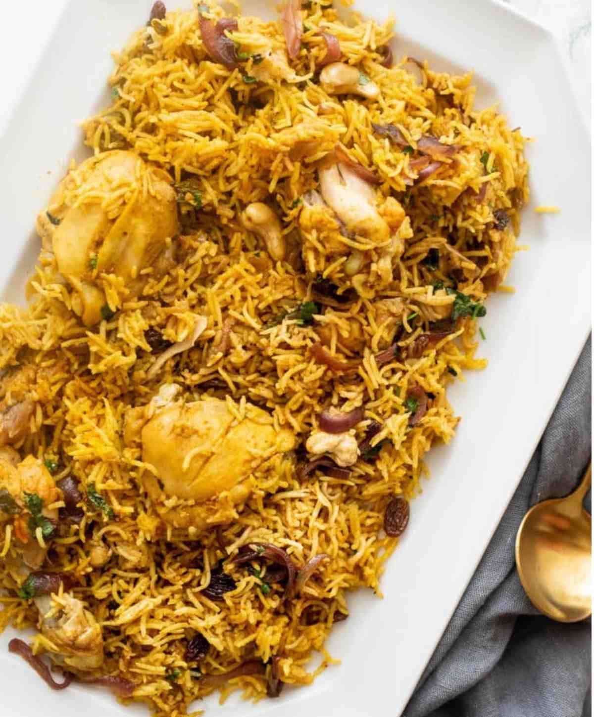 Chicken biryani served with a golden spoon 