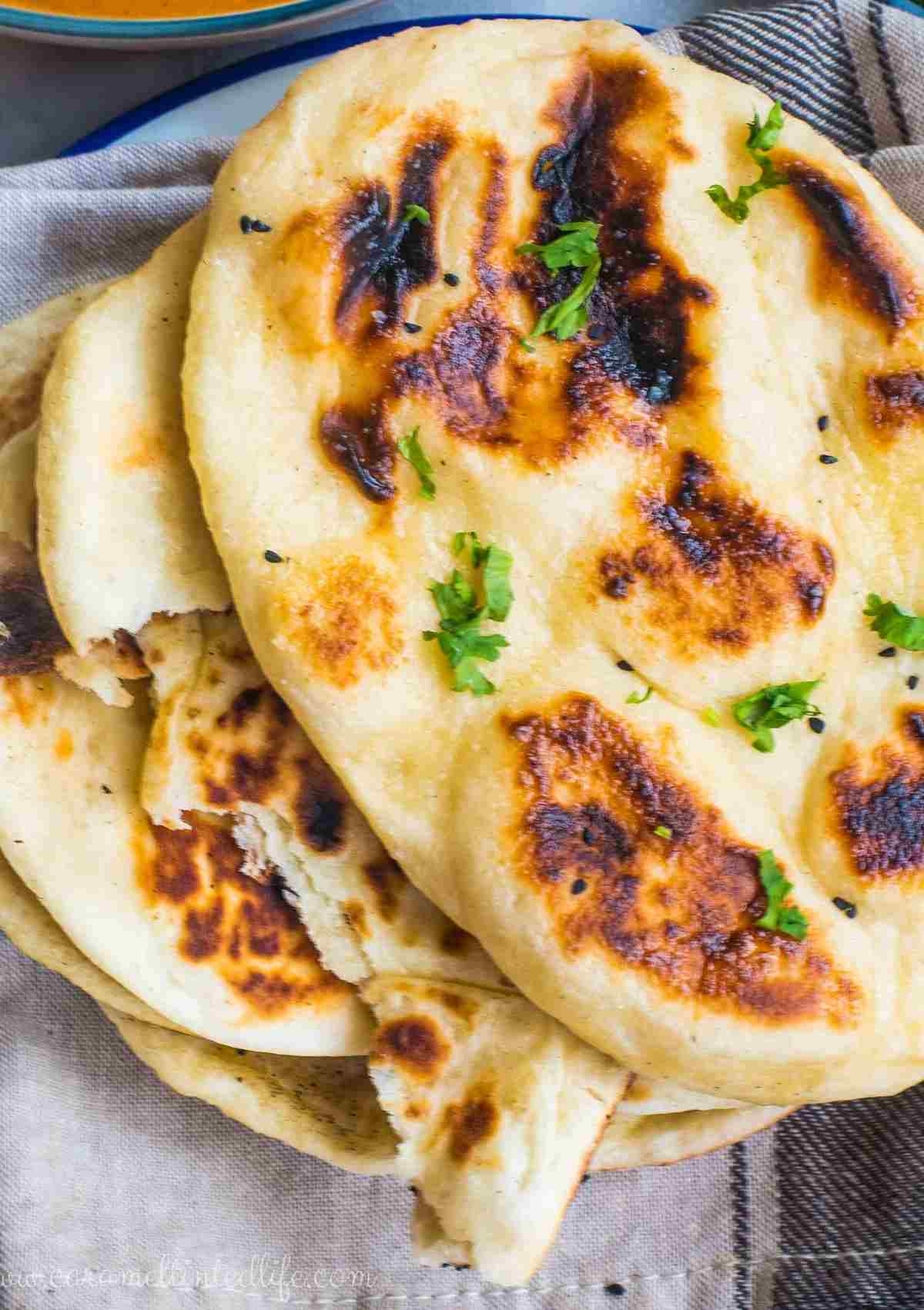 Close-up of naan bread stacked on a kitchen towel