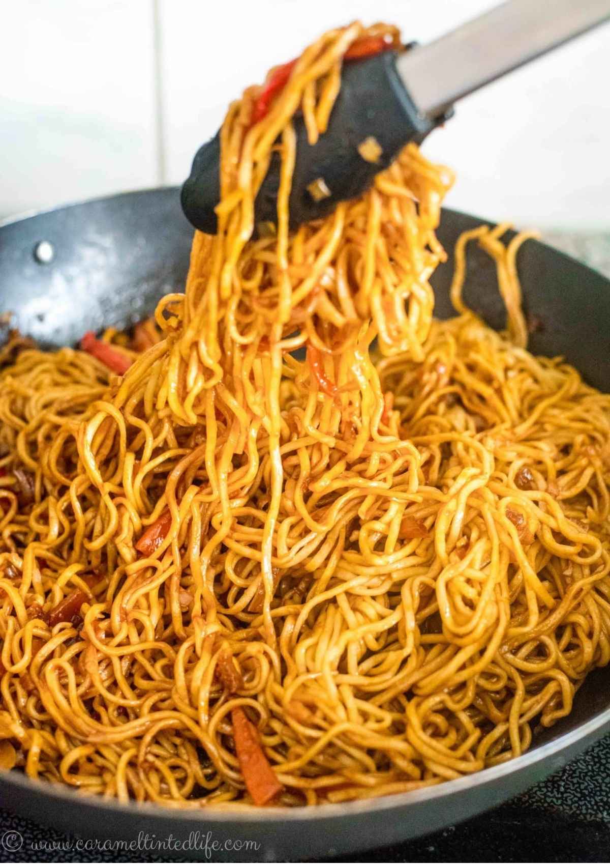 Noodles being tossed in a wok