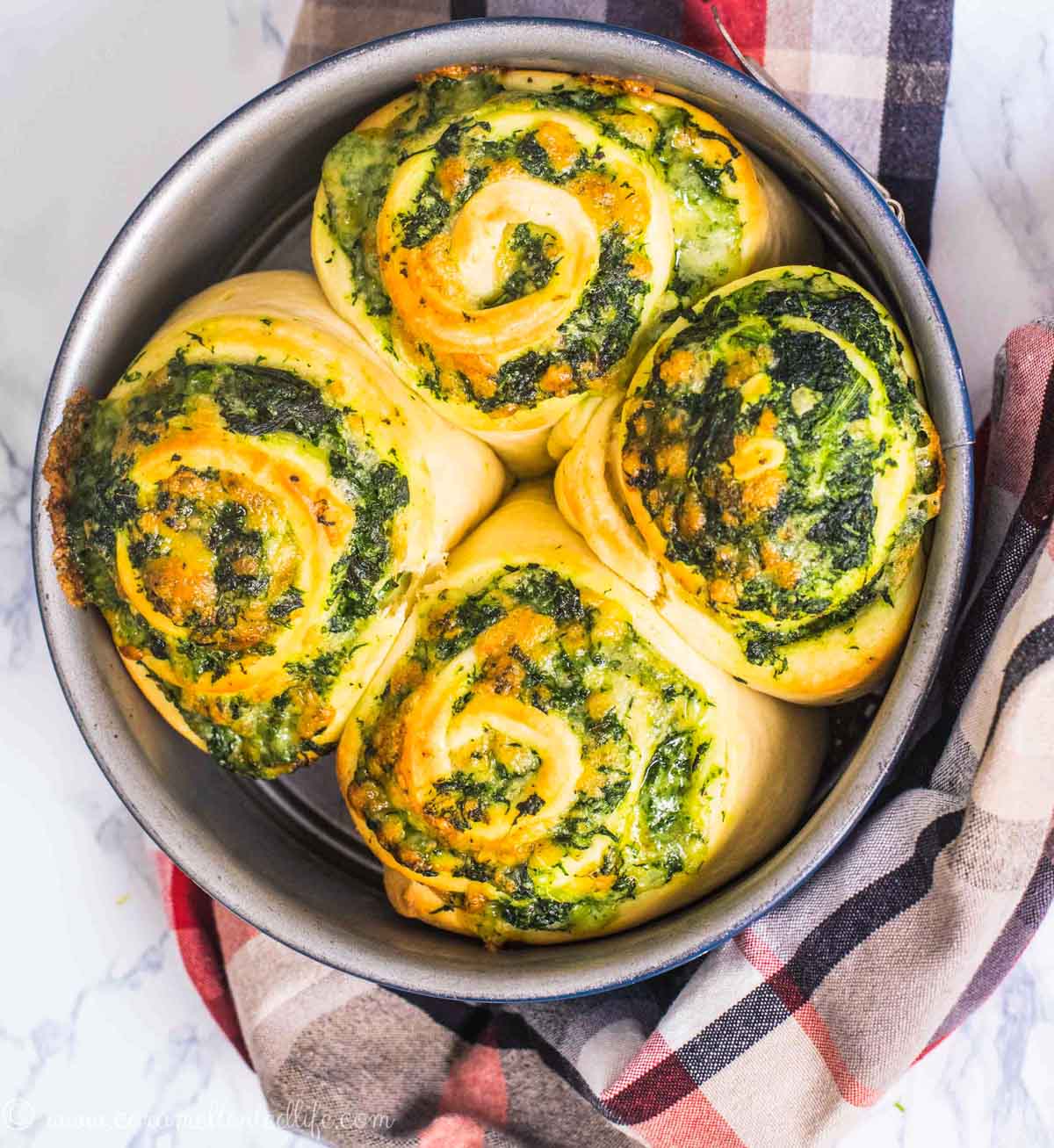 Baked savory bread rolls stuffed with spinach and cheese in around cake pan 