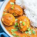 A bowl of egg curry and rice on a plate