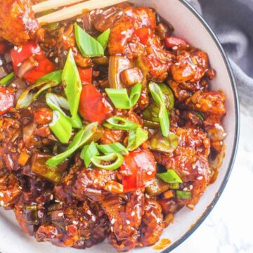 Sweet and sour cauliflower on a bowl with chopsticks