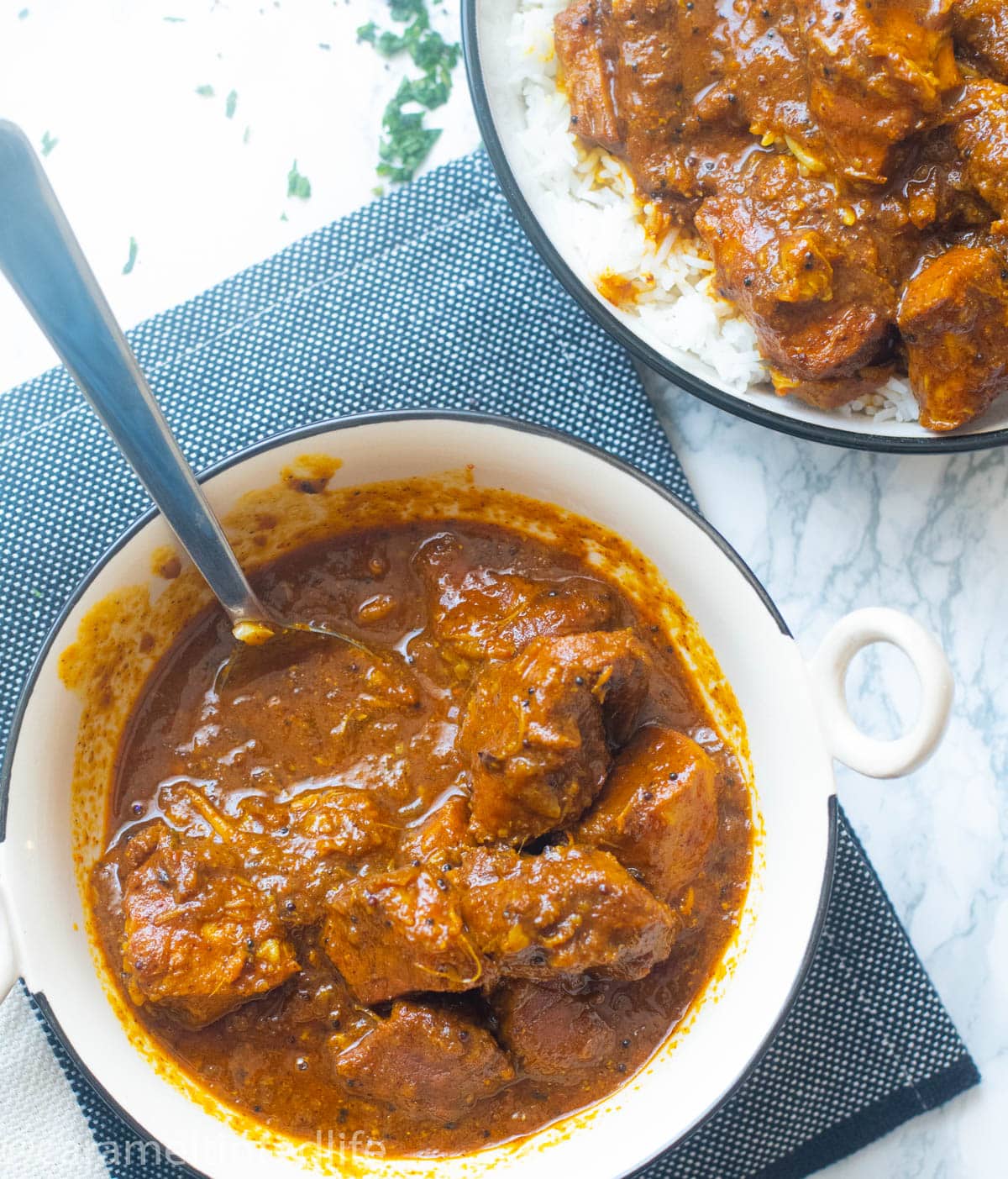 Pork vindaloo in a bowl with serving ladle