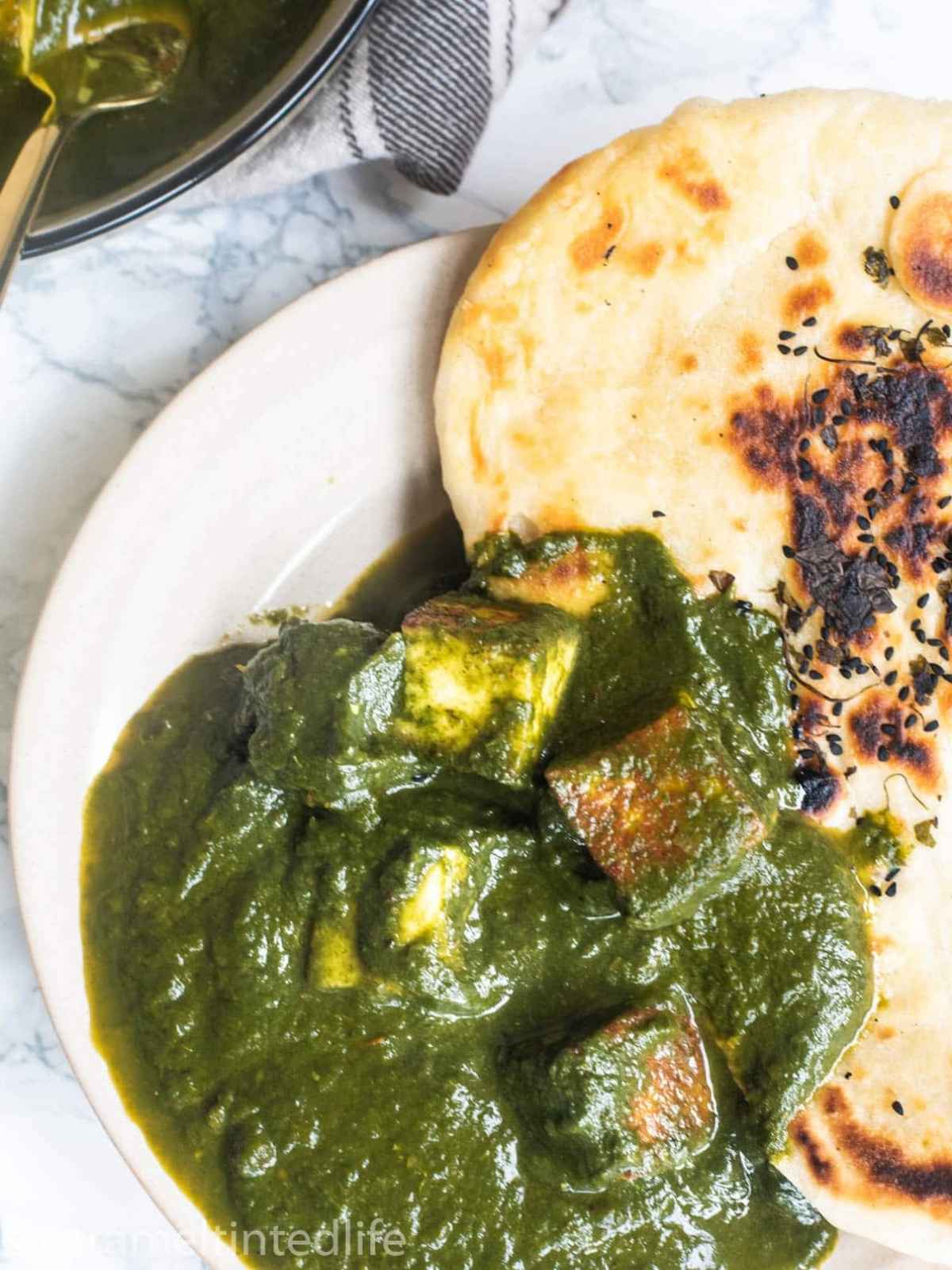 Saag paneer on a plate served with naan