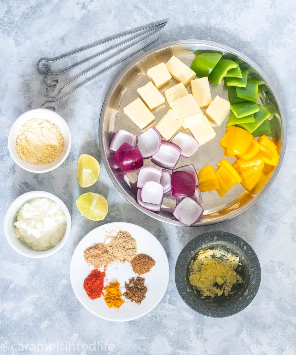 All Ingredients for making paneer tikka laid on a grey board