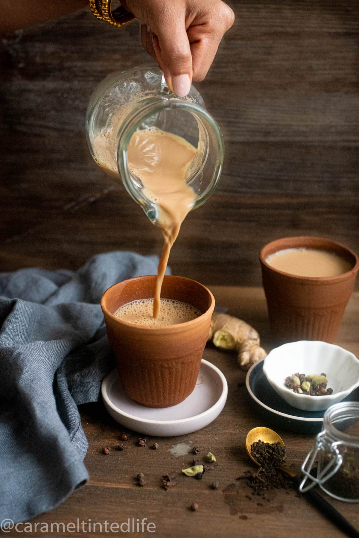 Masala chai being poured into a terracotta cup