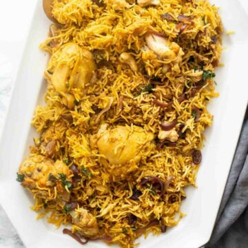 Chicken biryani served on a white tray with a spoon