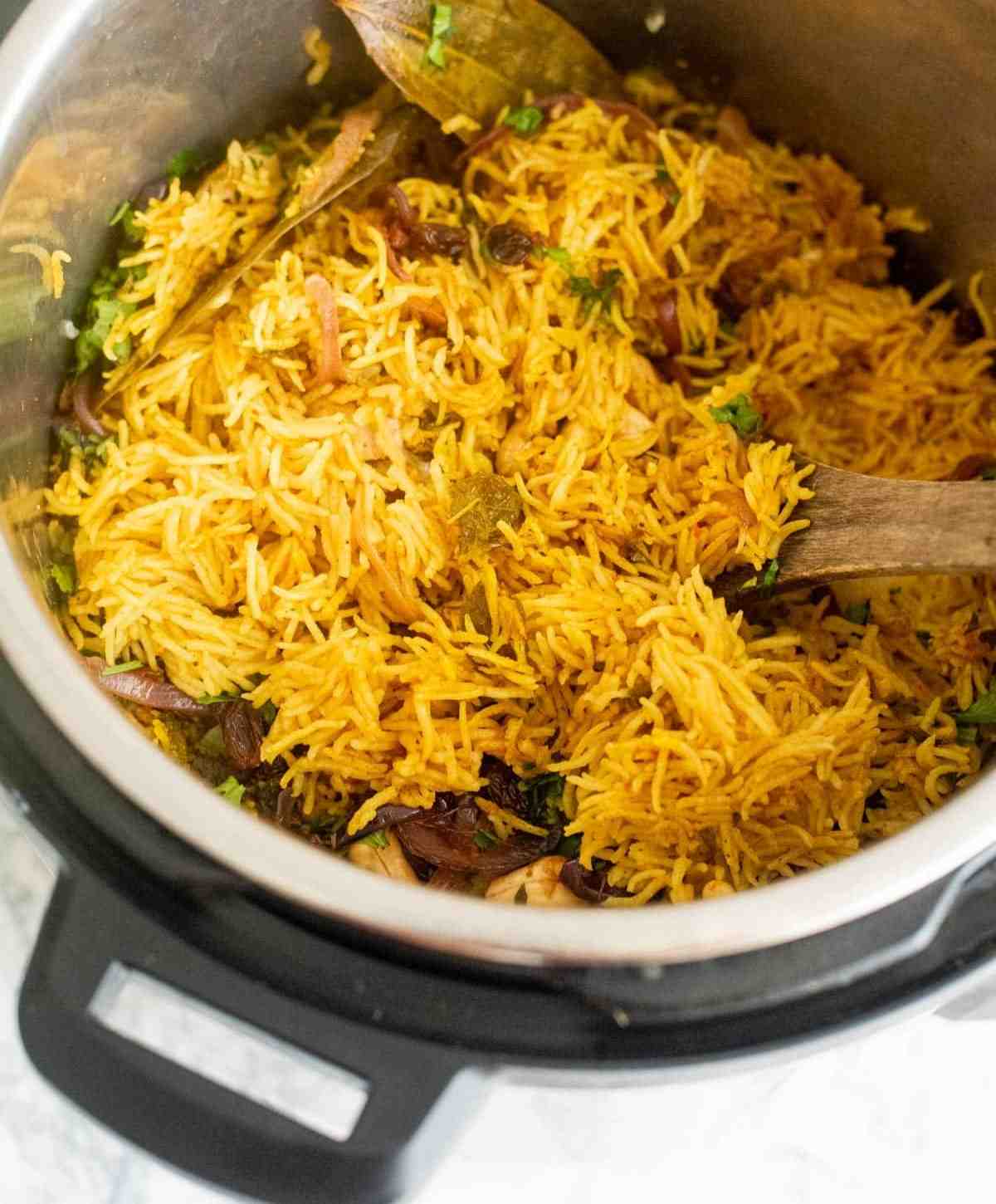 Chicken biryani inside an Instant Pot with a ladle