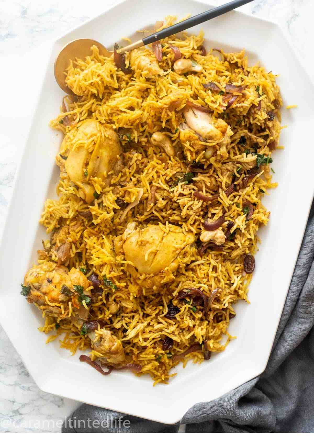 Chicken biryani served on a white tray with a spoon