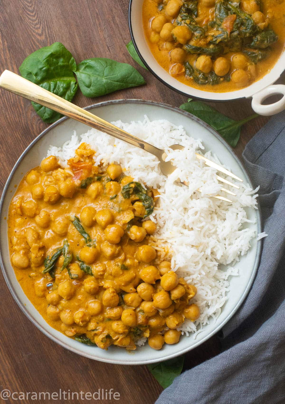 Coconut chickpea curry with spinach in a bowl with rice and a fork