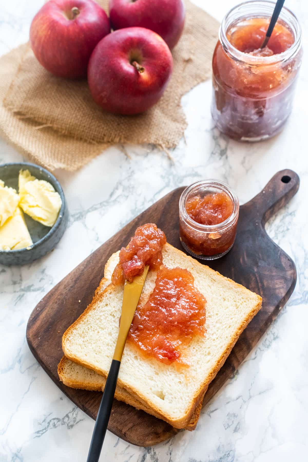 Apple jam spread on sandwich bread with a knife