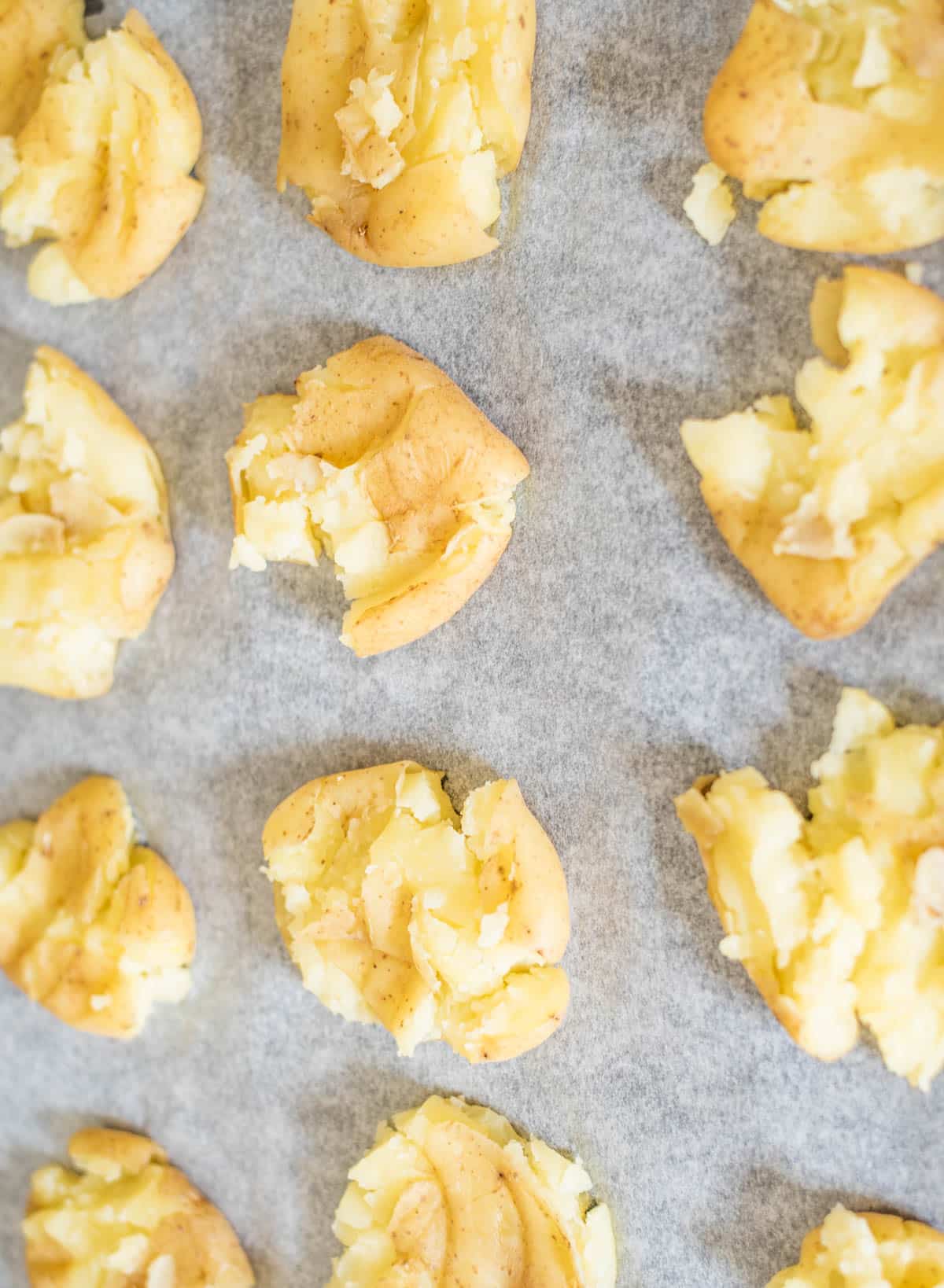 Smashed par-boiled potatoes on a baking tray 