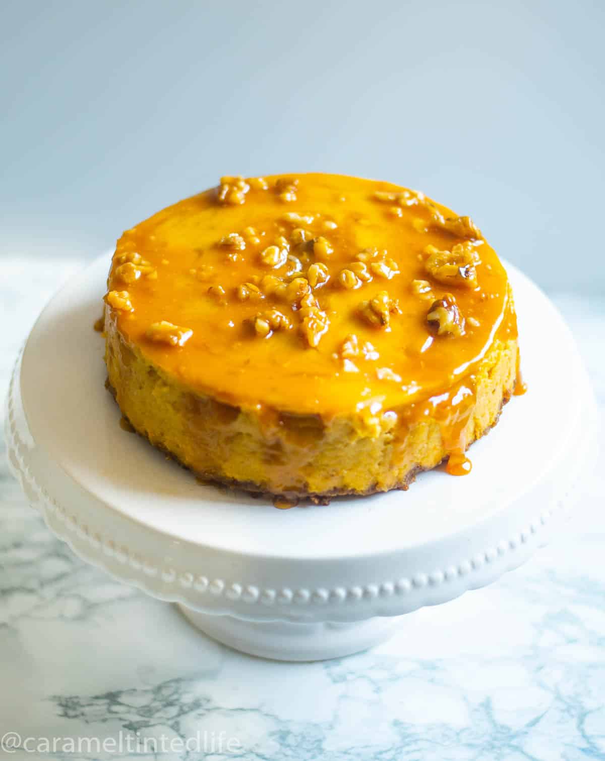 Pumpkin cheesecake on a white cake stand