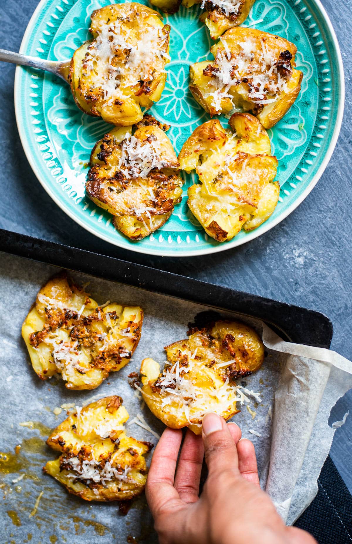 Tray of baked smashed potatoes held in a hand