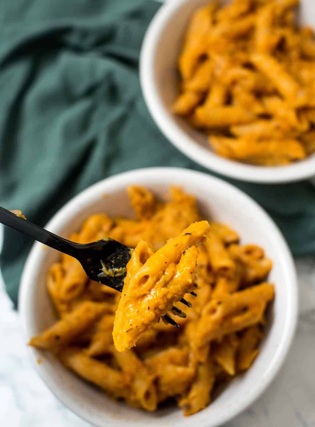 Fork holding pasta in butternut squash sauce