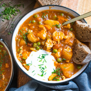 Chicken stew in a bowl with bread and sour cream garnish
