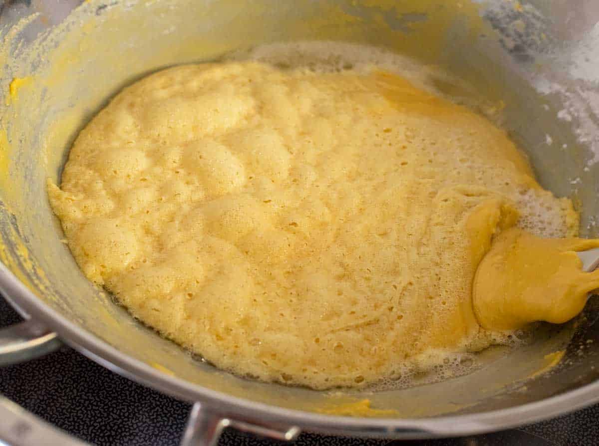 Frothy batter of chickpea flour, ghee and oil in a large steel wok