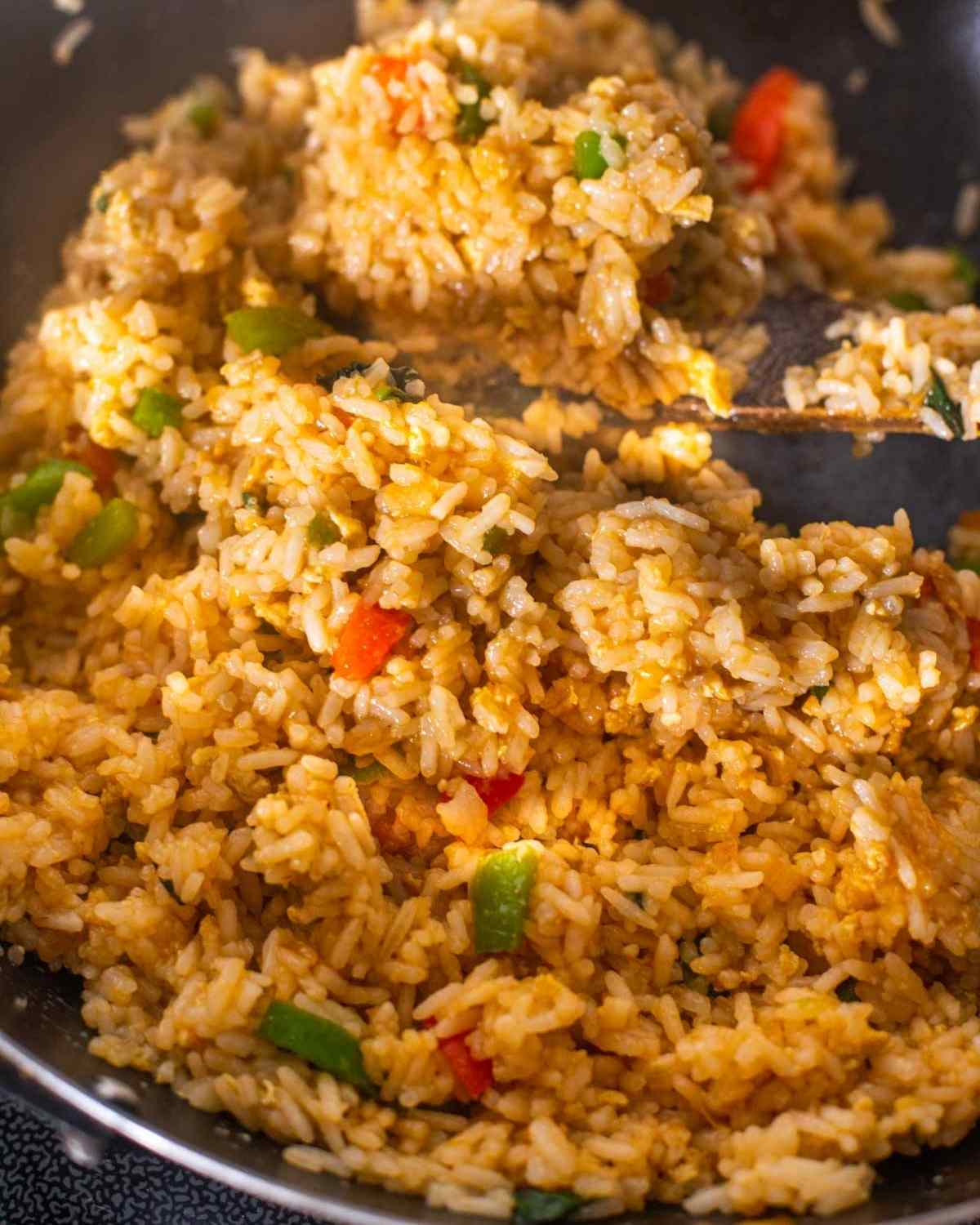 Fried rice being tossed in sauces in a wok