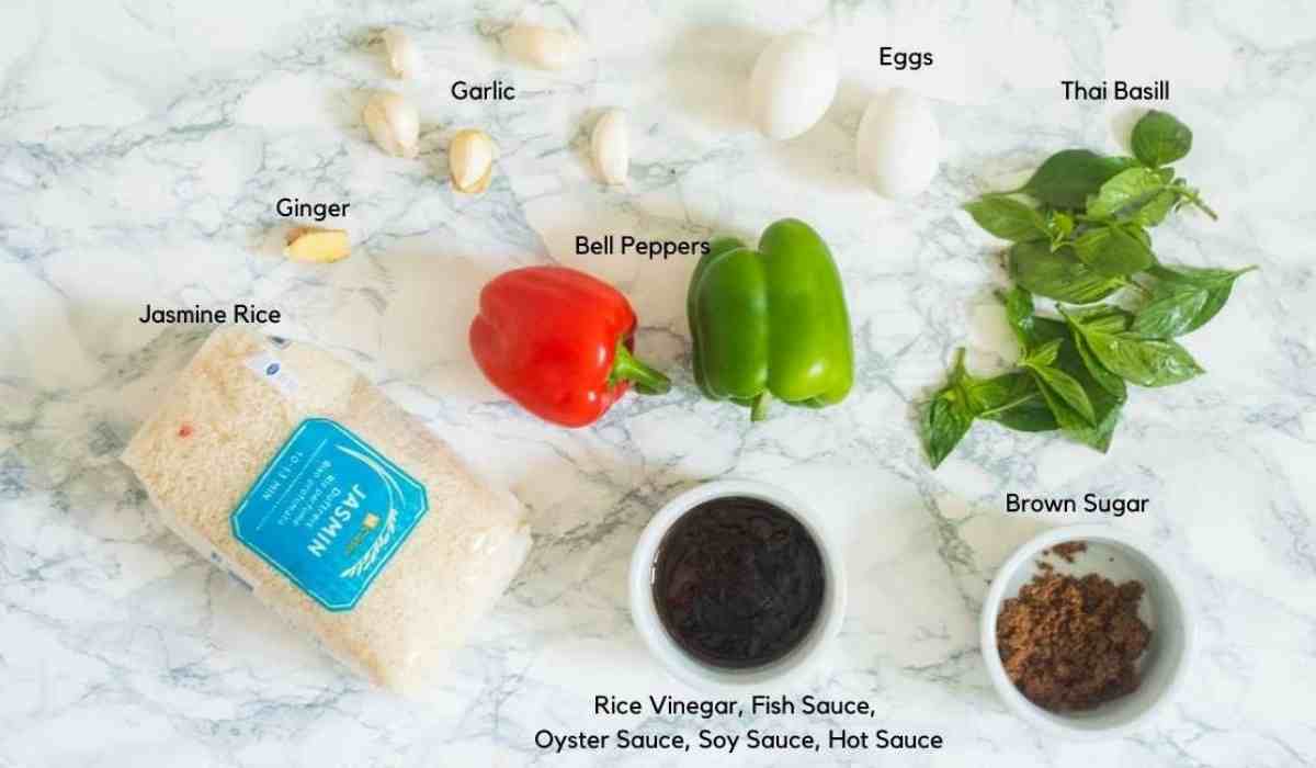 All the ingredients used to make basil fried rice, including jasmine rice, sauces, eggs, vegetables, sugar