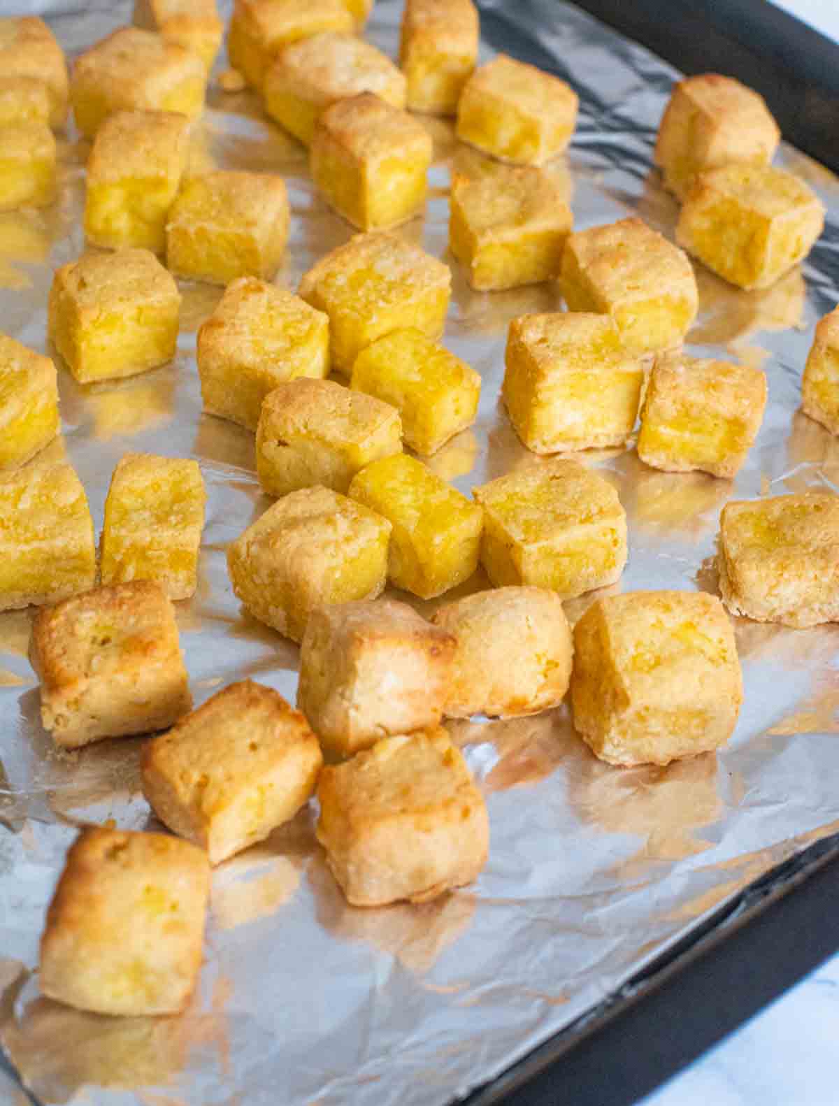 Crispy baked Tofu pieces on a baking sheet
