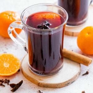 close up of a single glass of mulled wine on a wooden coaster