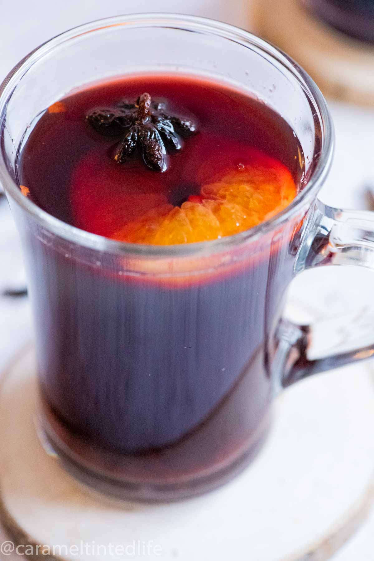 Close up of a glass of mulled wine with a star anise and orange slice