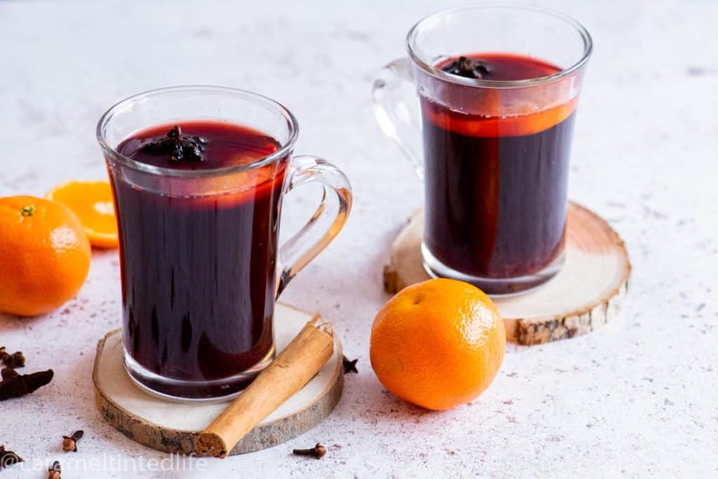 Two glasses of mulled wine resting a wooden coasters