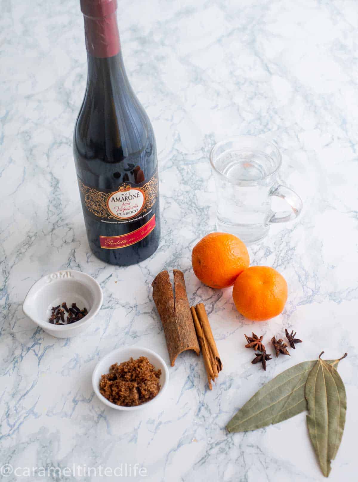 Ingredients used to make mulled wine, on a white surface