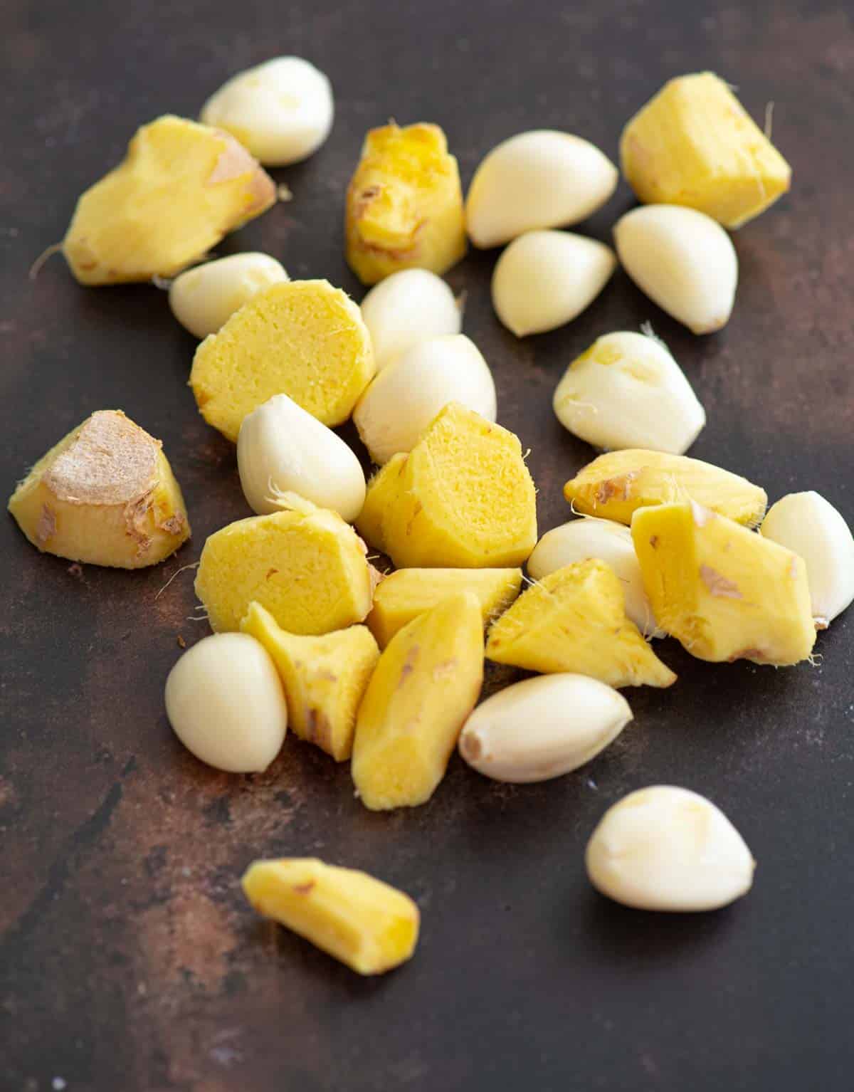 Peeled ginger and garlic on a brown surface