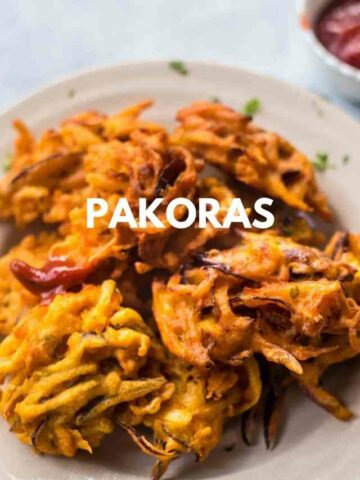 Pakoras on a plate, dipped in ketchup