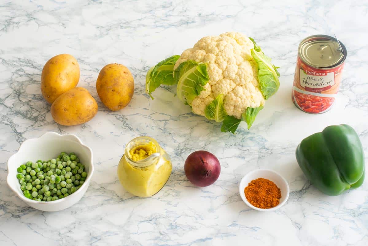 All ingredients needed to make pav bhaji on a white surface