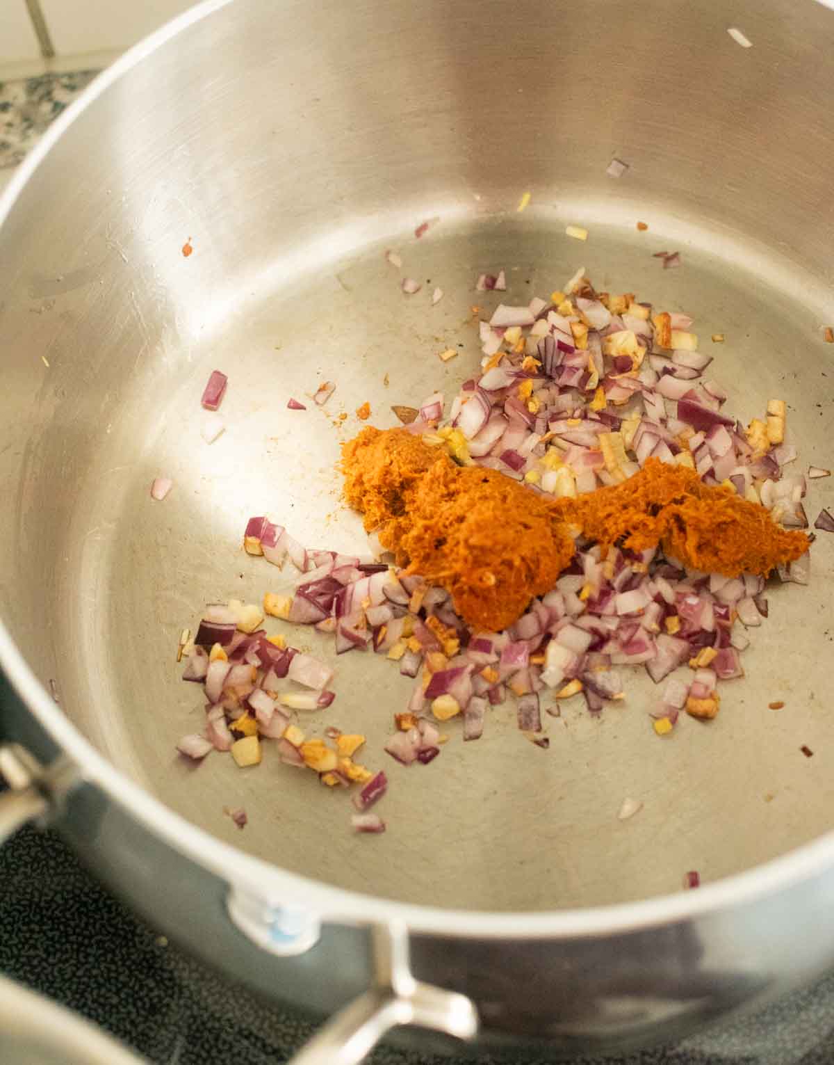 Onions and Thai curry paste in a pot on the stovetop