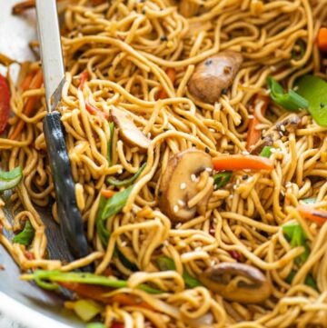 Vegetable Chow Mein scooped up with tongs