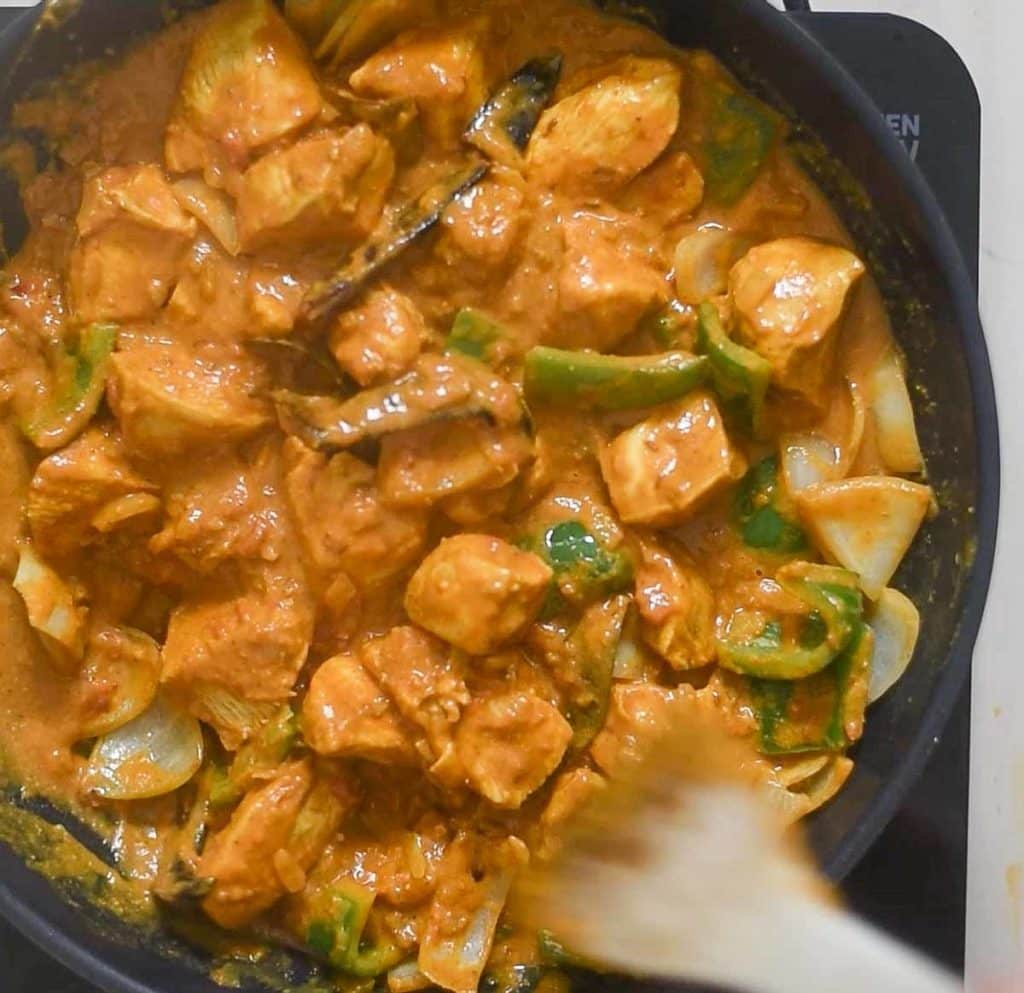 Addition of chicken to sauteed bell pepper and onion 