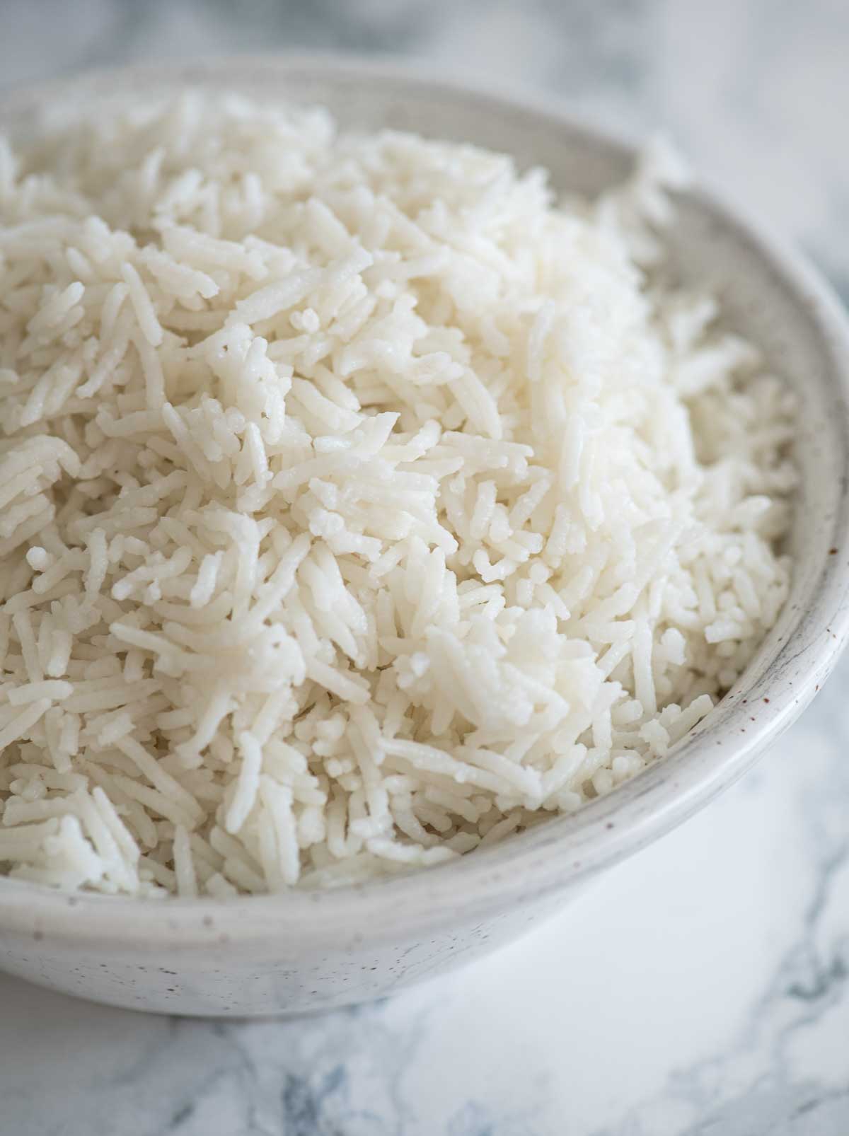 A bowl of basmati rice on a white background