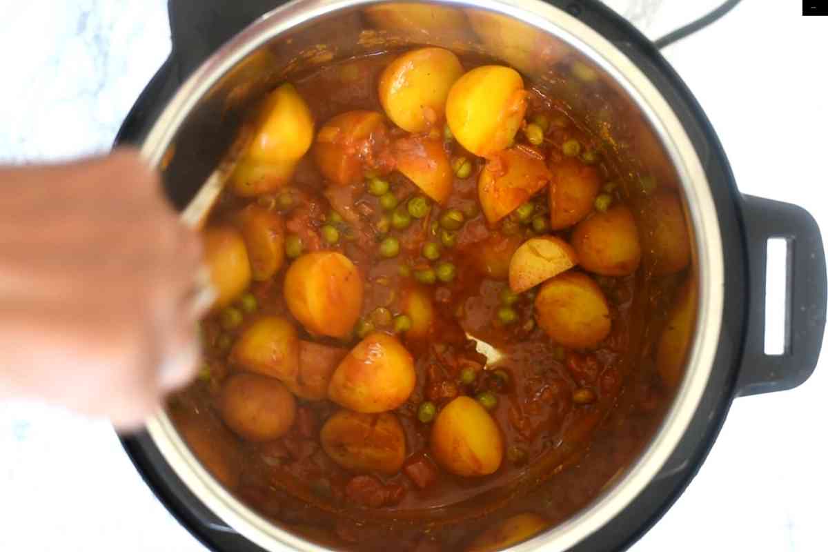 Ladle stirring potatoes and peas curry in an Instant Pot