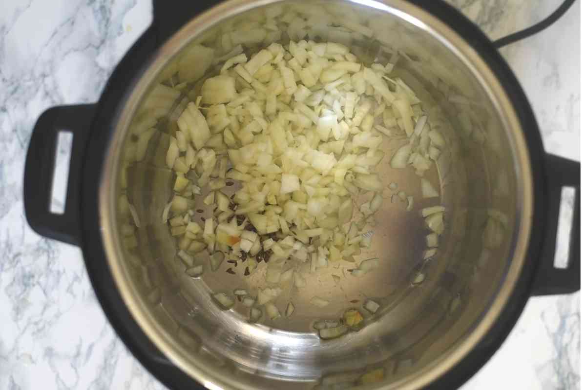 onions and cumin in an Instant Pot
