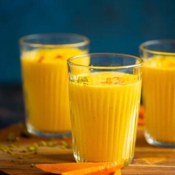 Mango clices in front of glasses of mango lassi