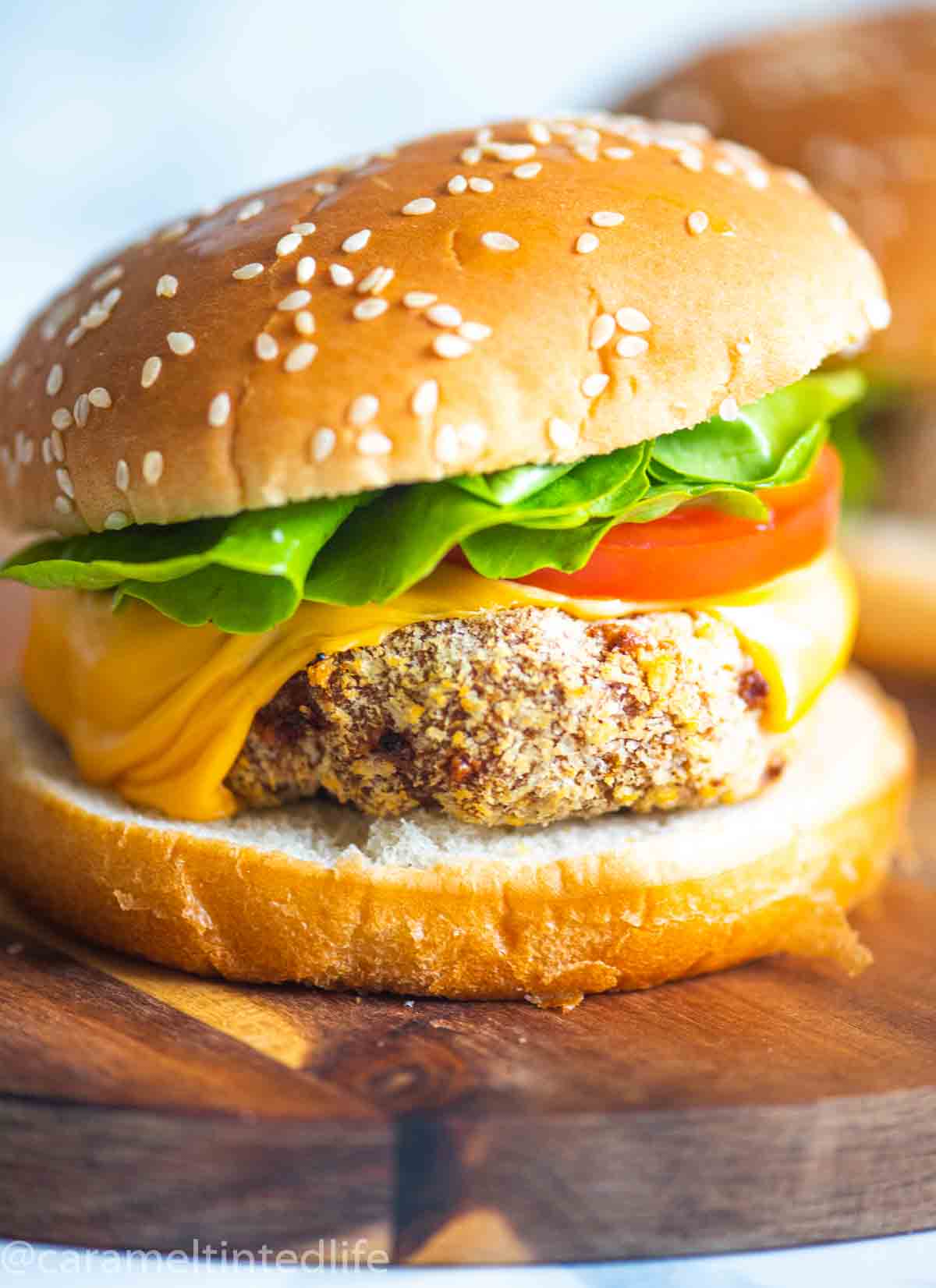 a Close up of a chicken burger on a wooden surface