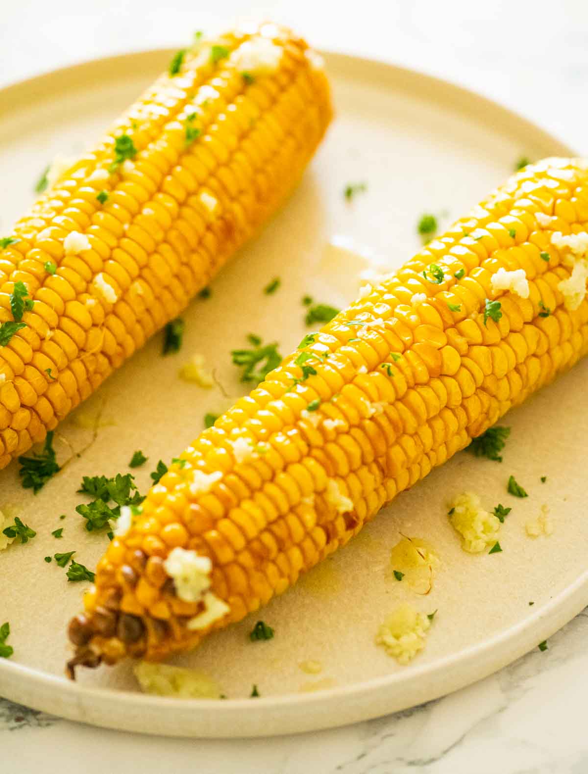 Close up of corn on the cob on a cream colored plate