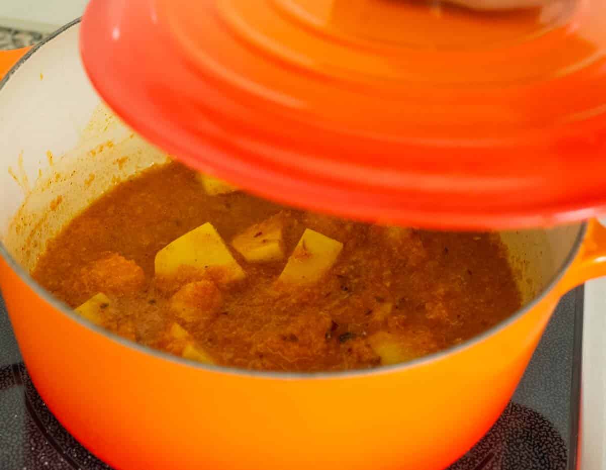 orange dutch oven with potatoes and curry