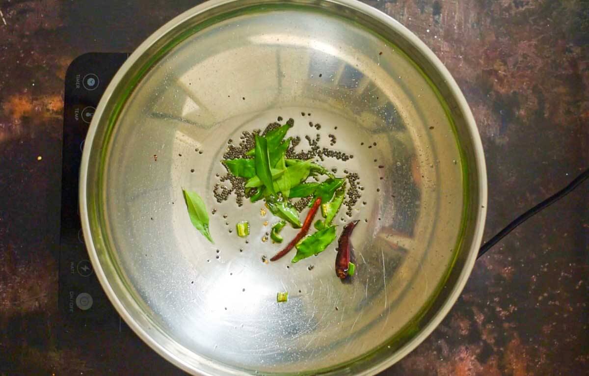 whole spices and curry leaves in a wok