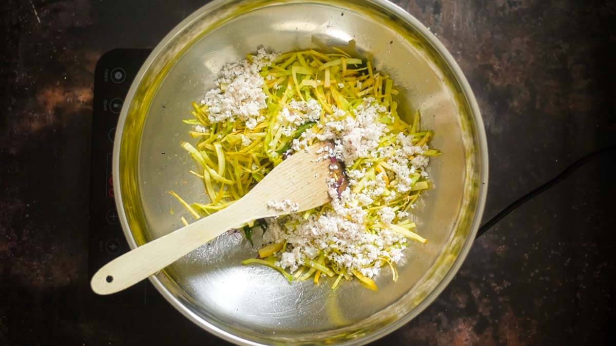 wok with shredded cabbage coconut and spices with wooden spatula