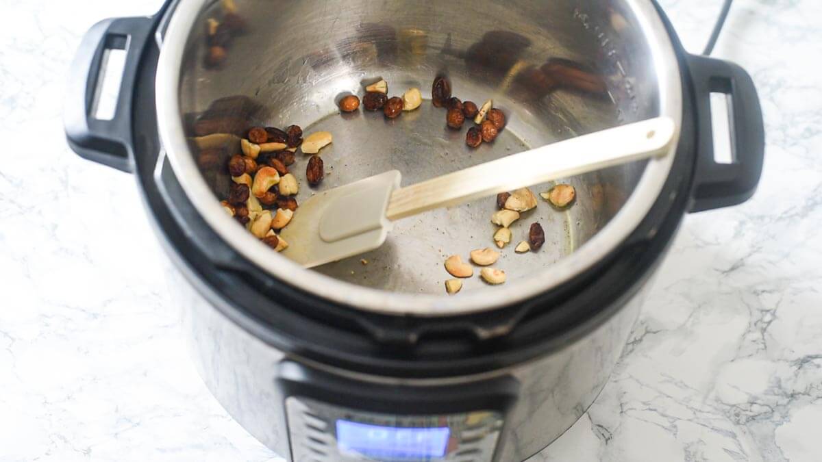 Instant Pot with raisins and cashews and a splatula