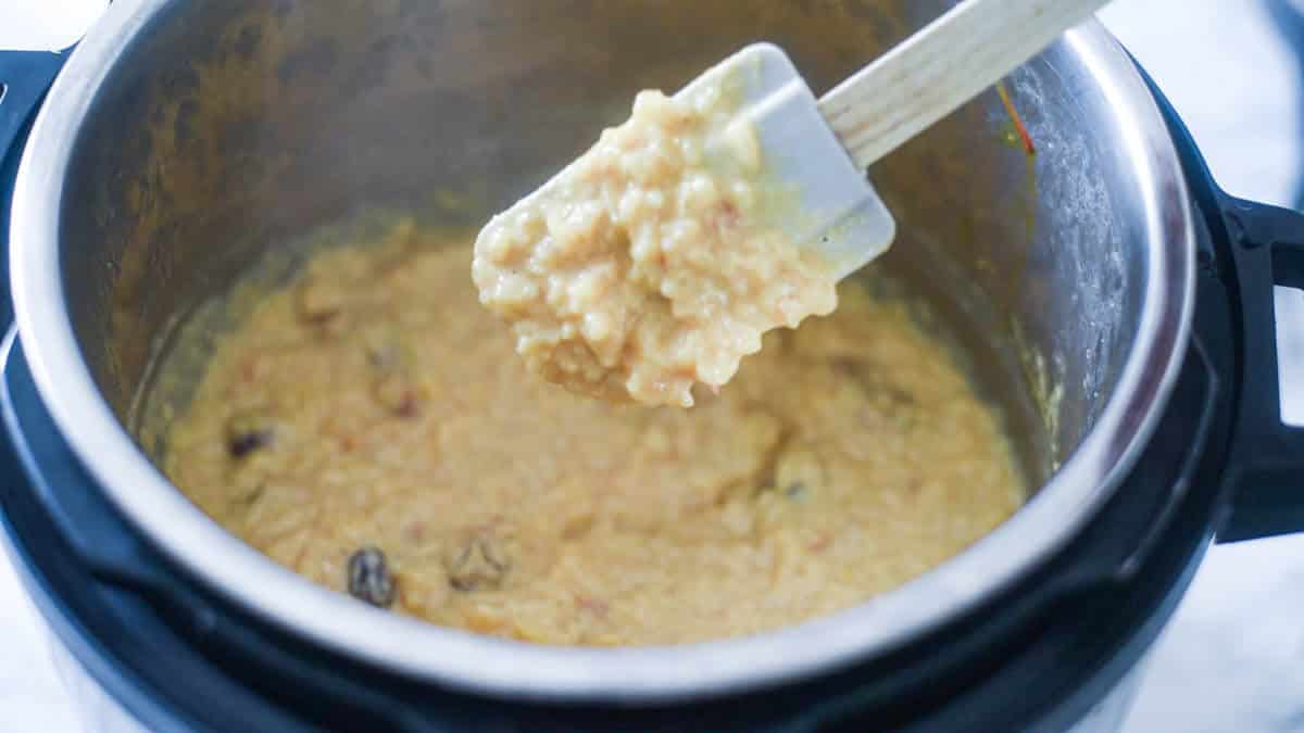 spatula holding rice kheer over an instant pot